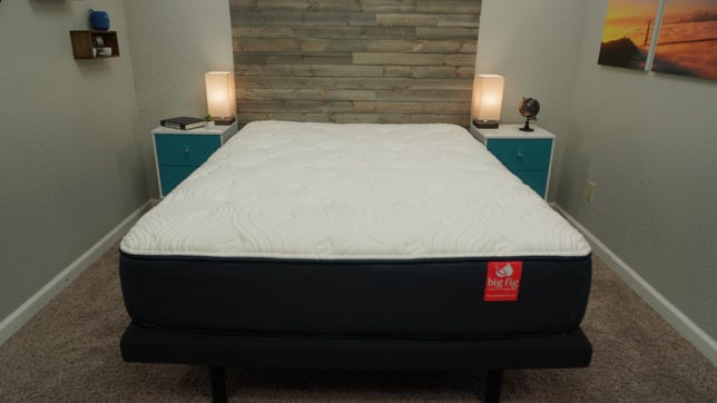 A Big Fig mattress on a grey bed frame in between two nightstands. 