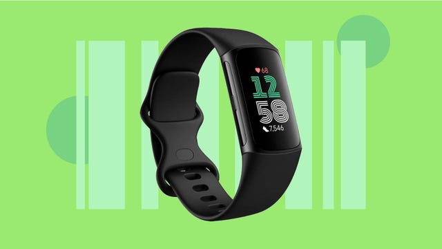 A black Fitbit fitness tracker against a green background.