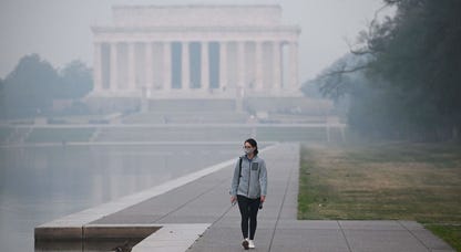 A person walks near the Lincoln Memorial under a blanket of haze in Washington, DC, on June 8, 2023.