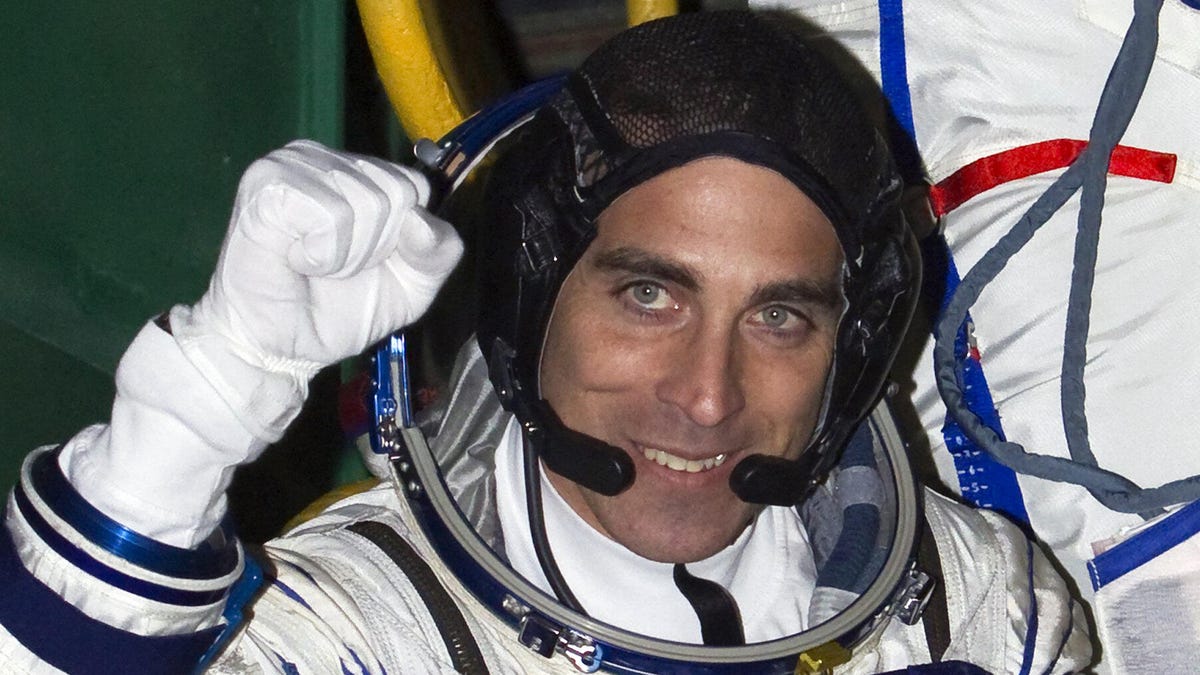 Astronaut Chris Cassidy, suited up but helmetless, smiles and pumps his fist in 2013.