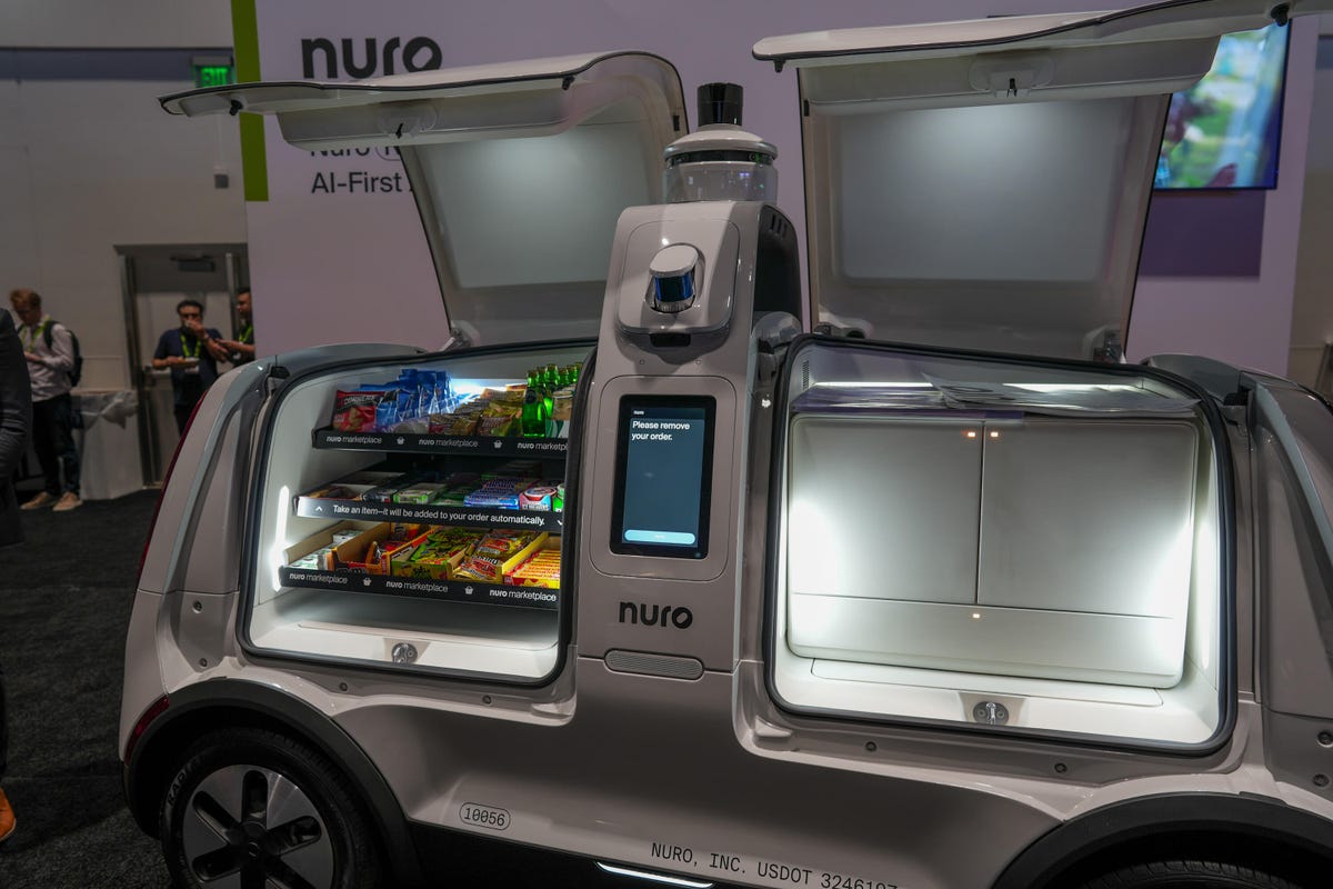Compartimentos abiertos en el Nuro R3 que muestran refrigerios y almacenamiento