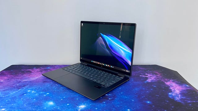 HP Spectre x360 14 Intel Core Ultra laptop at an angle against a gray wall