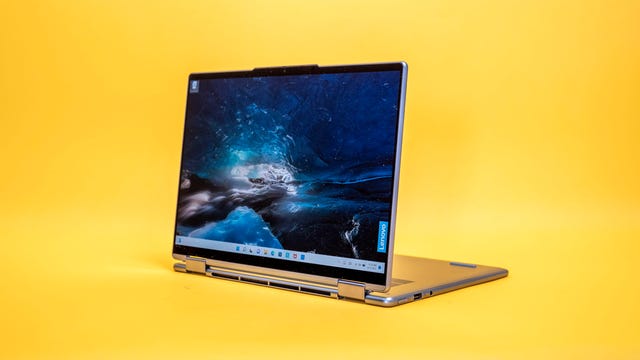 Laptop dos en uno Lenovo Yoga 7i 2022 de 14 pulgadas en modo soporte con la pantalla hacia la izquierda sobre un fondo amarillo