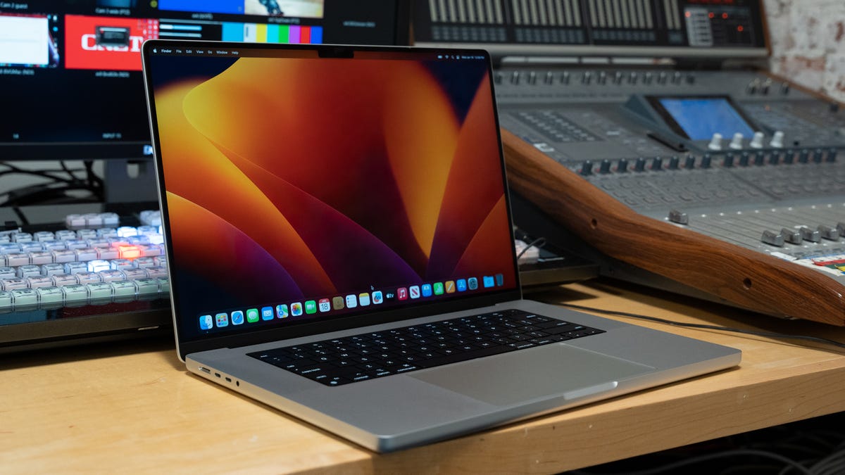 The Apple MacBook Pro 16 open in front of a studio's multicamera video control setup