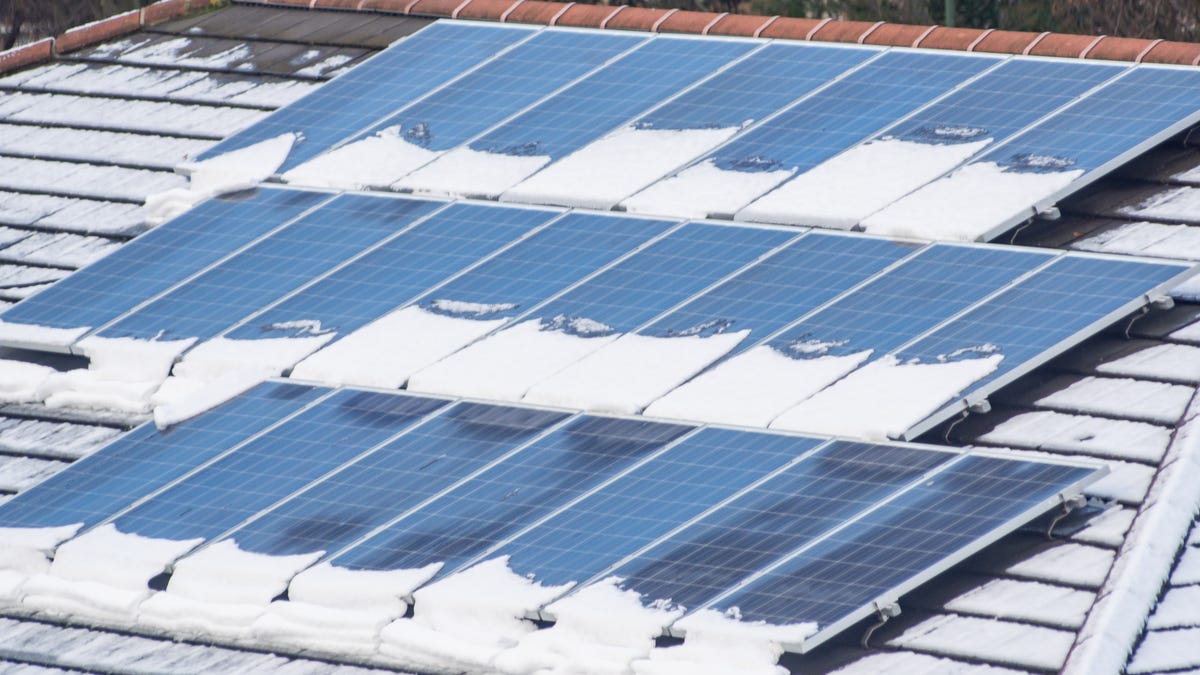 rooftop solar panels partially covered in snow