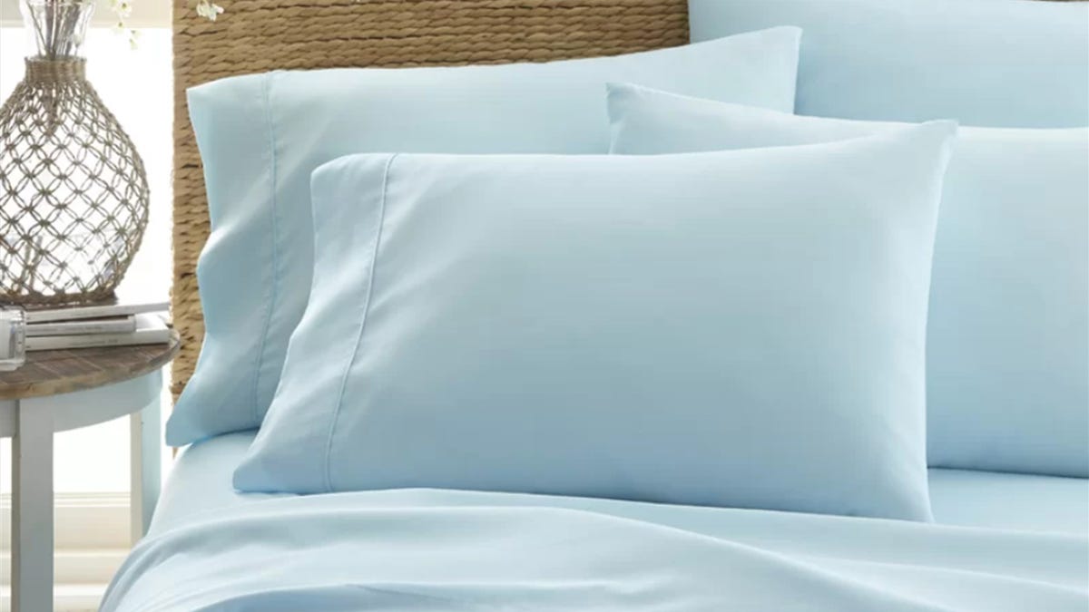 Up-close view of a bed made up with pale aqua sheets and pillow cases.
