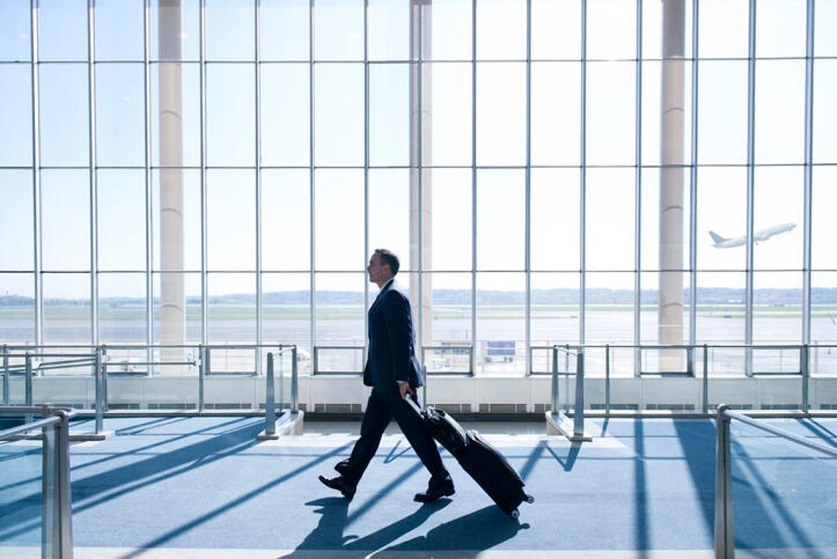 A man walking through an airport terminal. 
