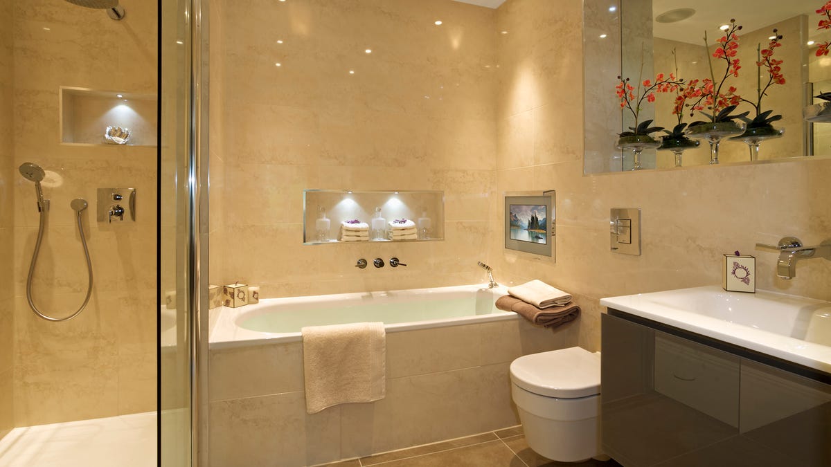 A bathroom with tub, shower and screen, among other fixtures