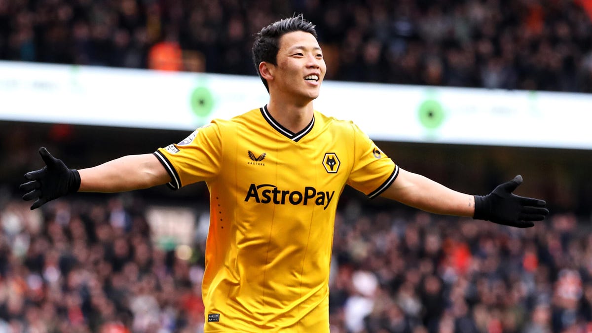 Hee chan Hwang of Wolves, celebrating, smiling, with both arms outstretched.
