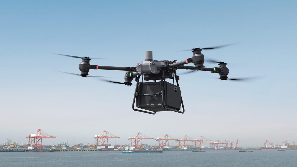 DJI&apos;s Flycart 30 drone carrying a large box with a shipping port in the background