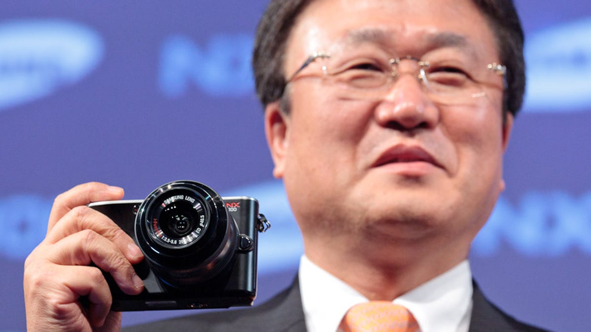 Sangjin Park, president of Samsung&apos;s digital imaging division, holds the NX100 at a press conference at the Photokina show in Cologne, Germany.