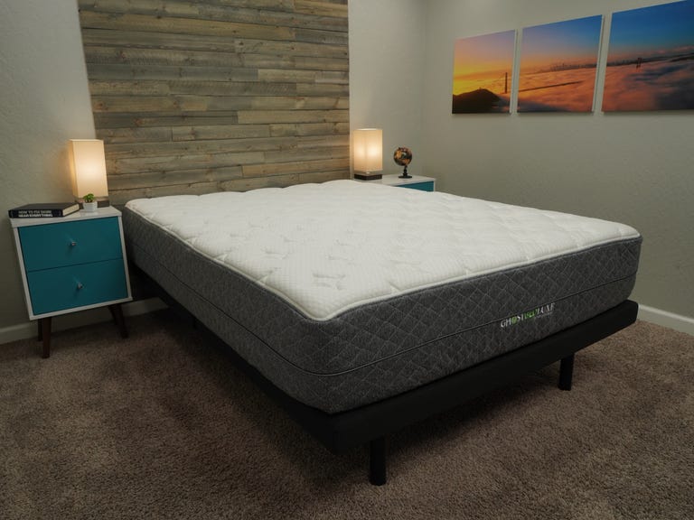 The GhostBed Luxe mattress in a bright room with a wooden back wall