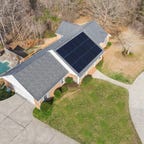 An aerial view of a house with solar panels on it.