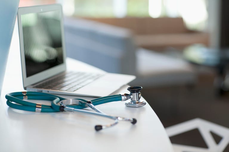 Laptop and stethoscope on desk
