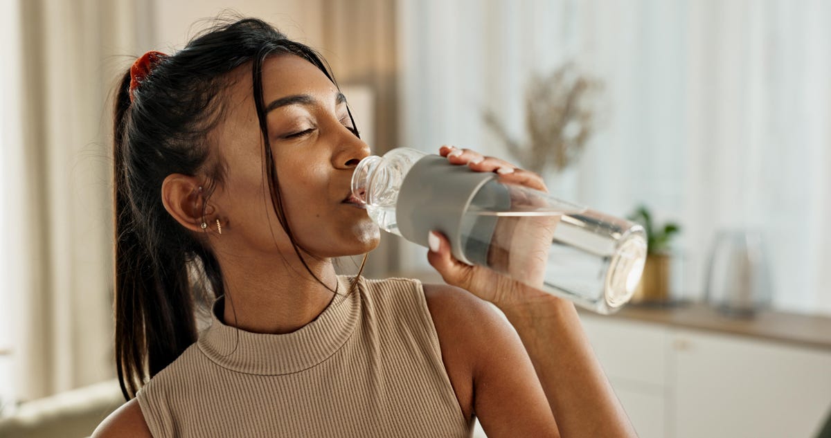 Woman drinking water from a water bottle.