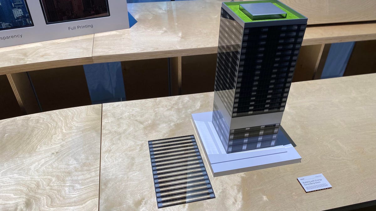 A model of a skyscraper with black lines on the windows representing potential perovskite solar cells.