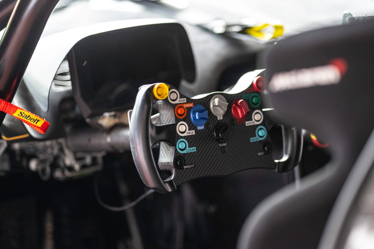 Interior of a McLaren Artura GT4 showing the steering wheel covered in colorful buttons