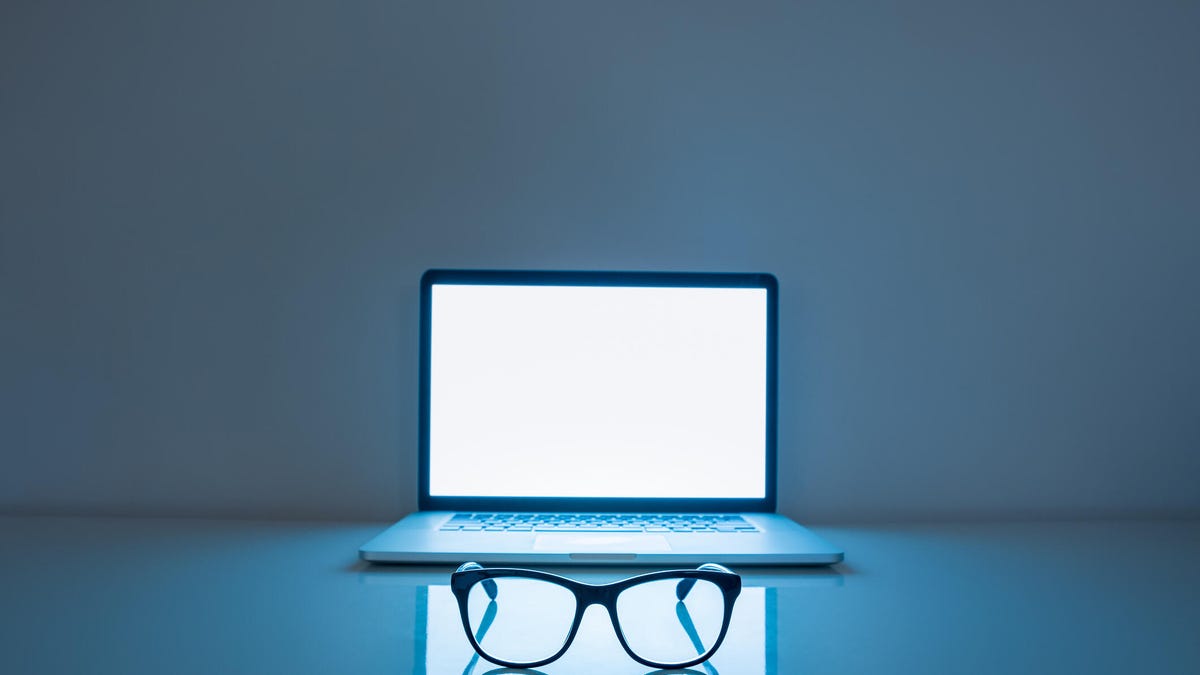 blue light from computer screen, with eyeglasses on table