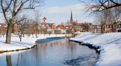 A view of Frederick, Maryland from the snow-covered banks of a creek.