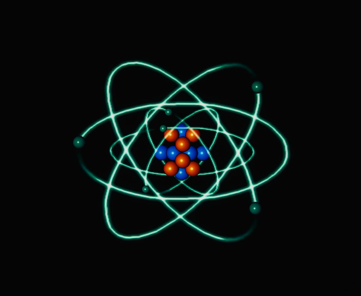 The image of the atomic structure shows green electrons orbiting blue and red protons and neutrons on a variety of scales.