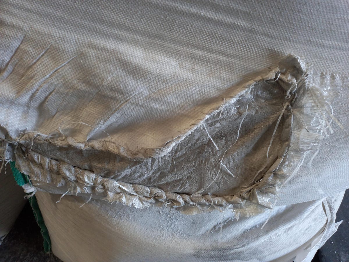 A torn mattress showing fiberglass beneath it