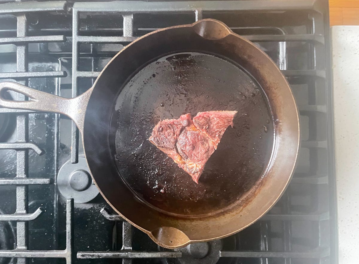 steak in cast iron skillet on stove