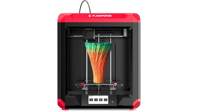 Een zwart-rode 3D-printer met een regenboogvaas erop
