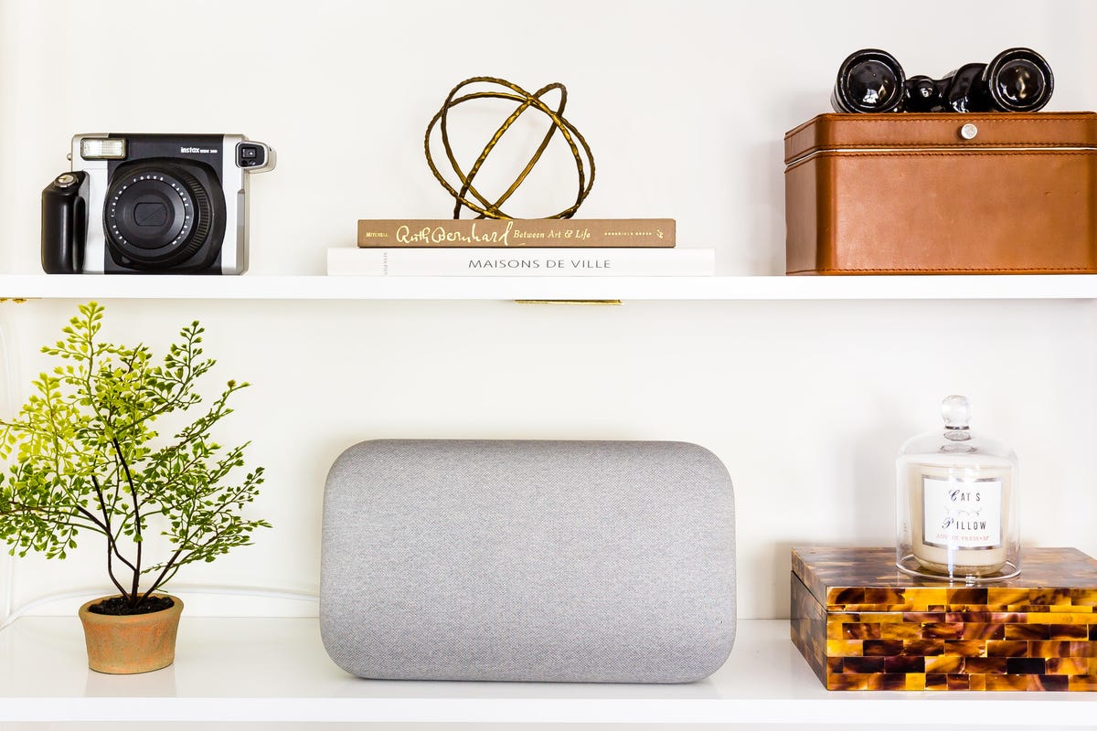 The Google Home Max speaker on a shelf with other objects.
