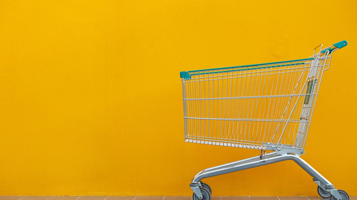 Empty Shopping Cart Against Yellow Wall
