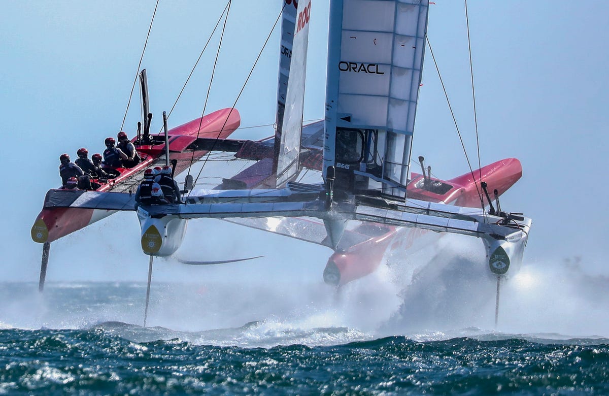 Two SailGP F50 boats rise up out of the water on their hydrofoils in a race in Cadiz, Spain.