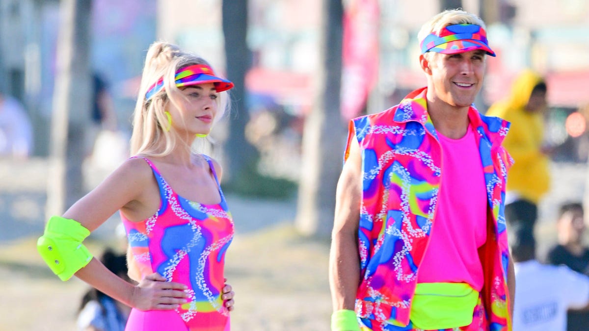 Robbie and Gosling wear matching pink, blue and yellow neon outfits while filming Barbie.