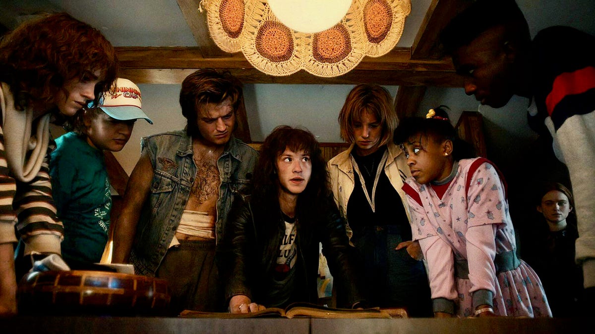 Characters from Stranger Things season 4 gathered around a table.