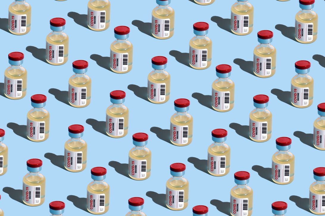 Multiple vials of COVID-19 vaccine on a light blue background.