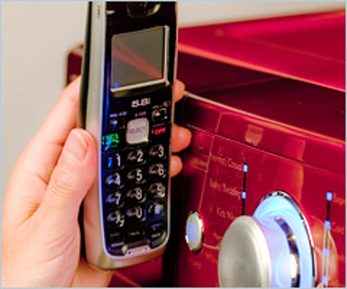A cordless telephone held near a Kenmore washing machine