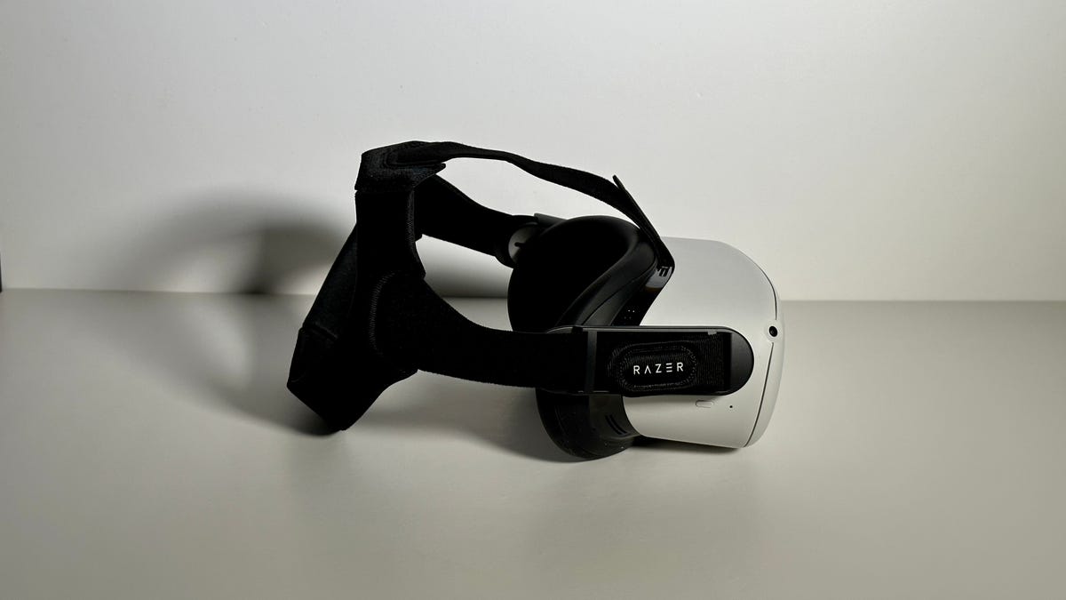 Quest 2 VR headset on a white table with a black Razer head strap on
