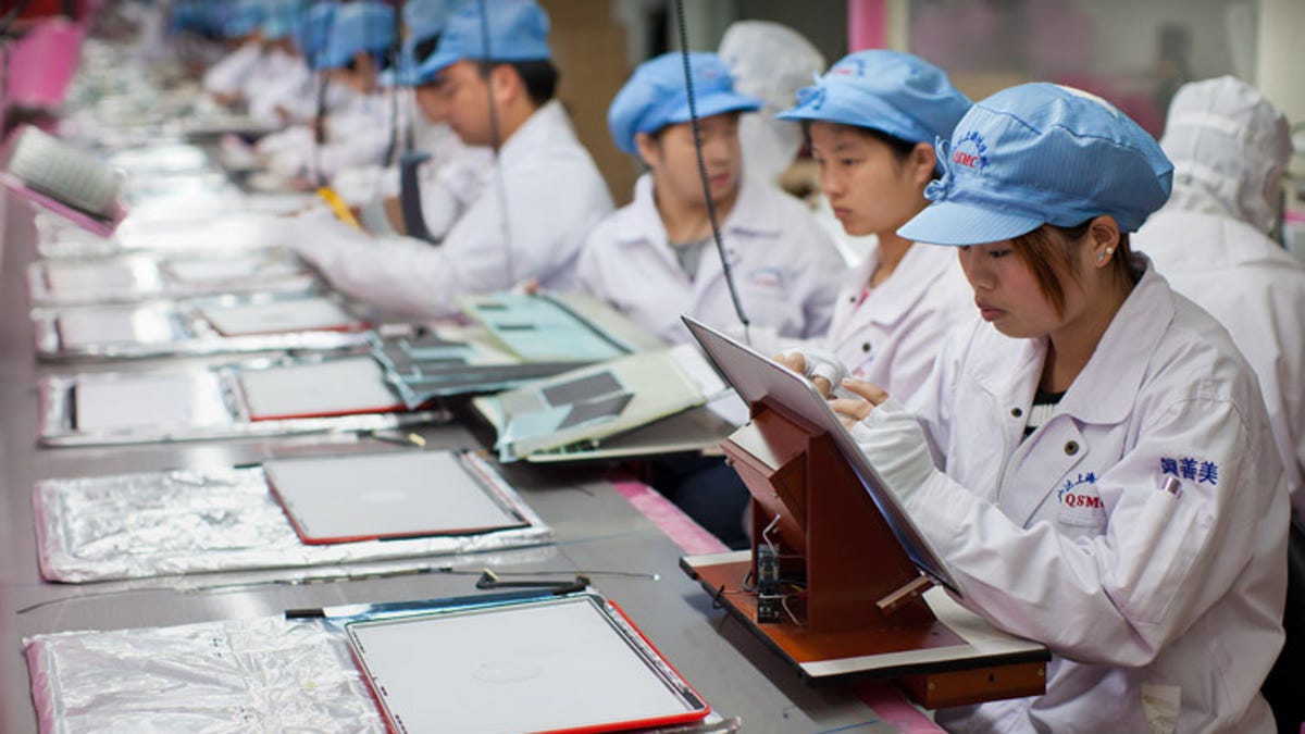 Apple supply workers assembling MacBook Pro displays in Shanghai.