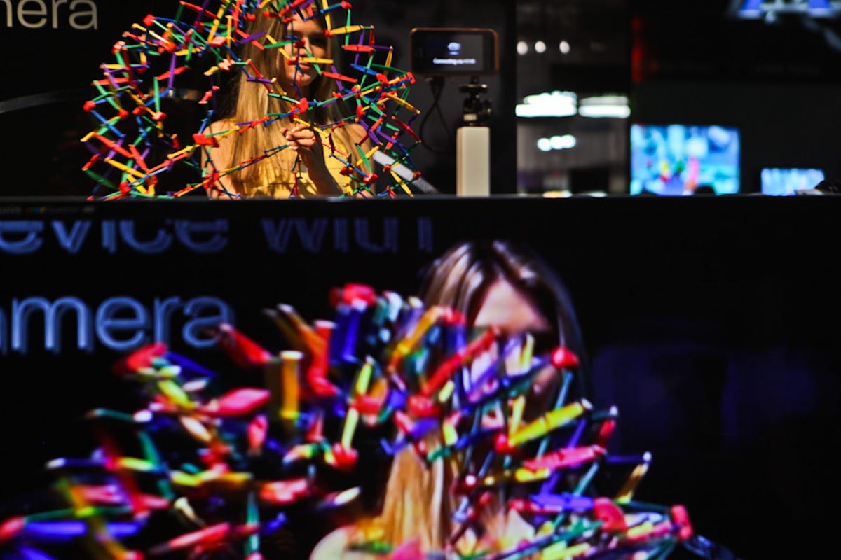 Demonstrating the capabilities and the quality of 3D video cameras, a show floor model dances with a colorful puzzle at the Sharp booth Friday afternoon.