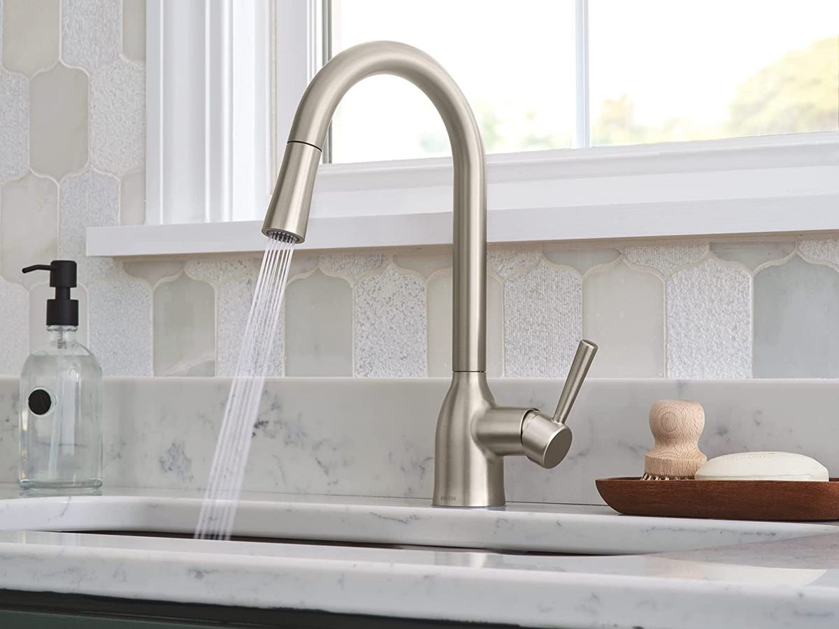 moen faucet mounted in a sink with water spraying.