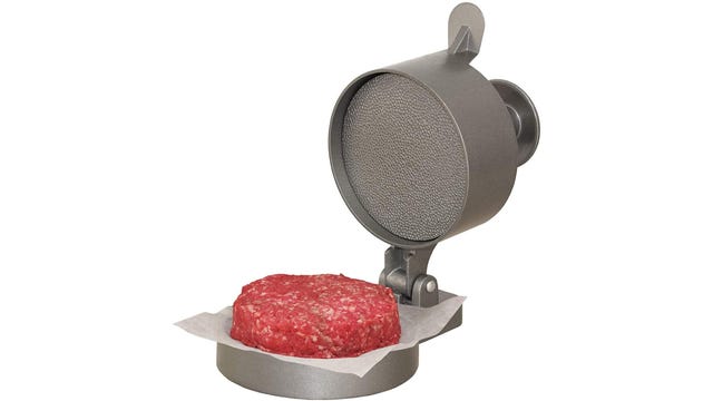 Metal hamburger press with a burger ready to cook