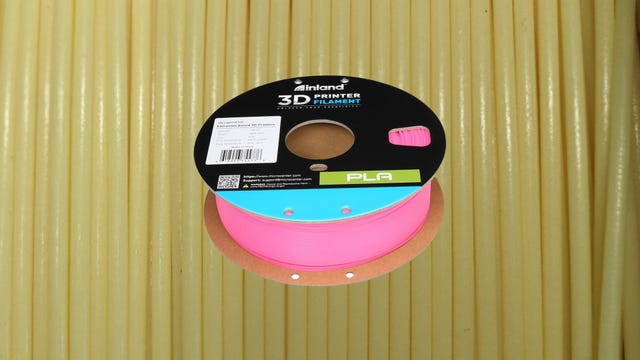 Pink PLA filament on a yellow background
