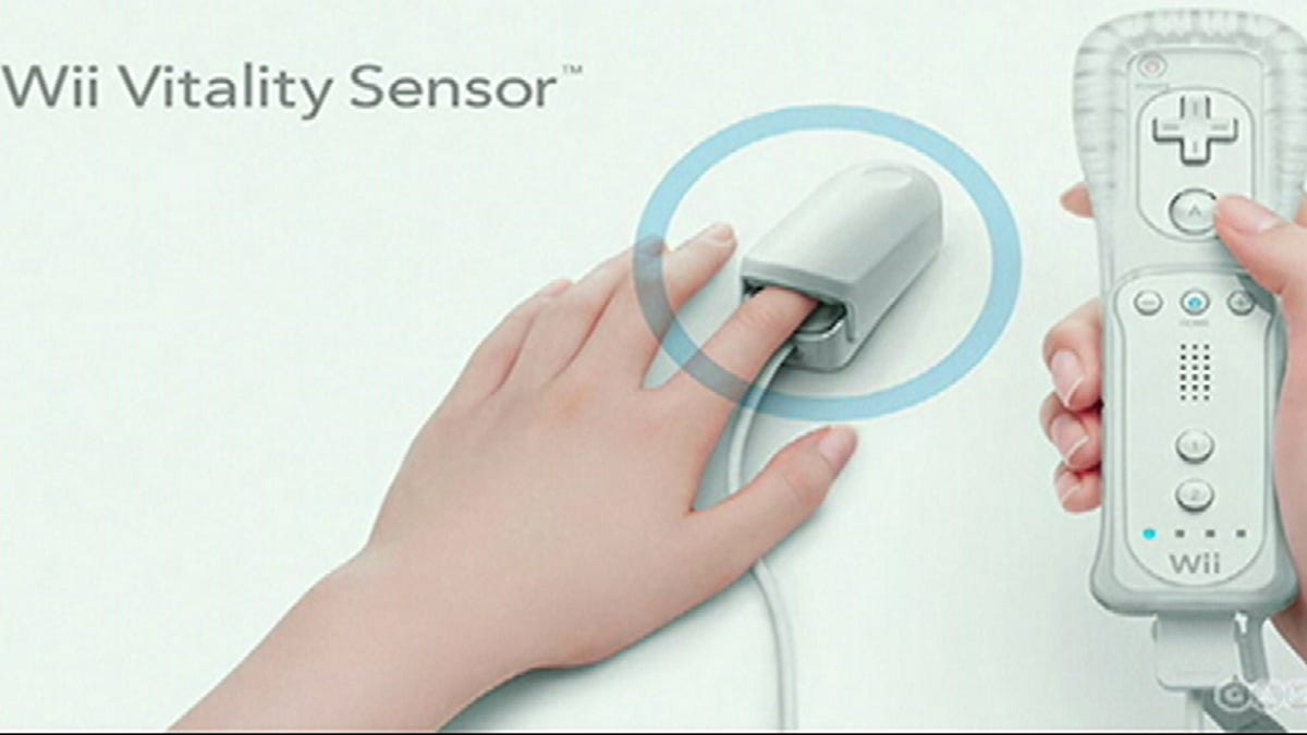 A Wii remote attached to a finger clip on someone's hand.