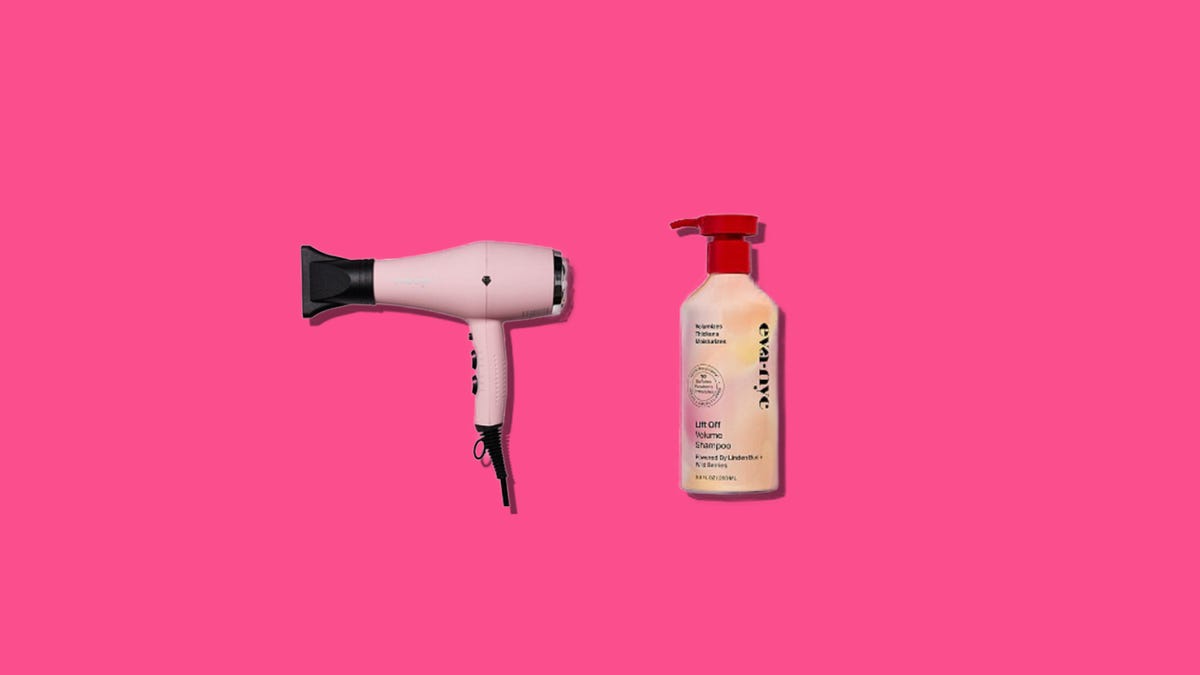 A pink hair dryer and pink shampoo bottle side by side