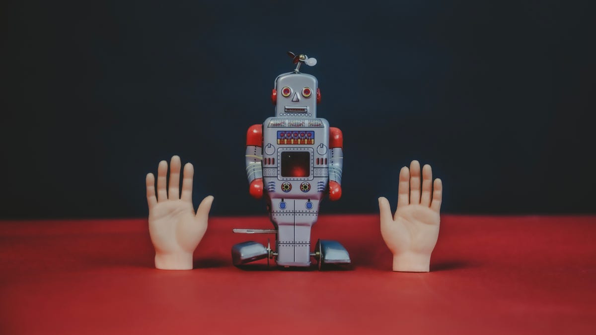 A robot alongside two small human hands