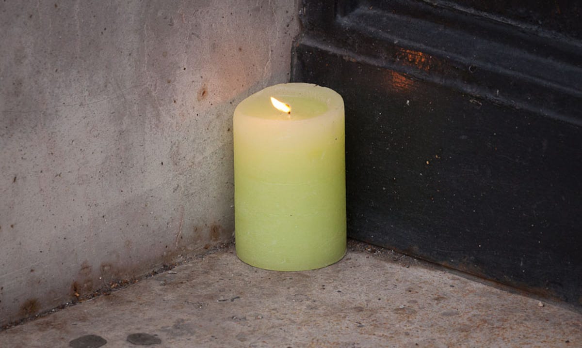 A solitary candle by a Paris Apple store door marked the death of company co-founder Steve Jobs.