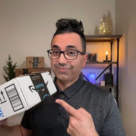 Sal Farzin pointing to an Amazon box with a bookshelf in the background