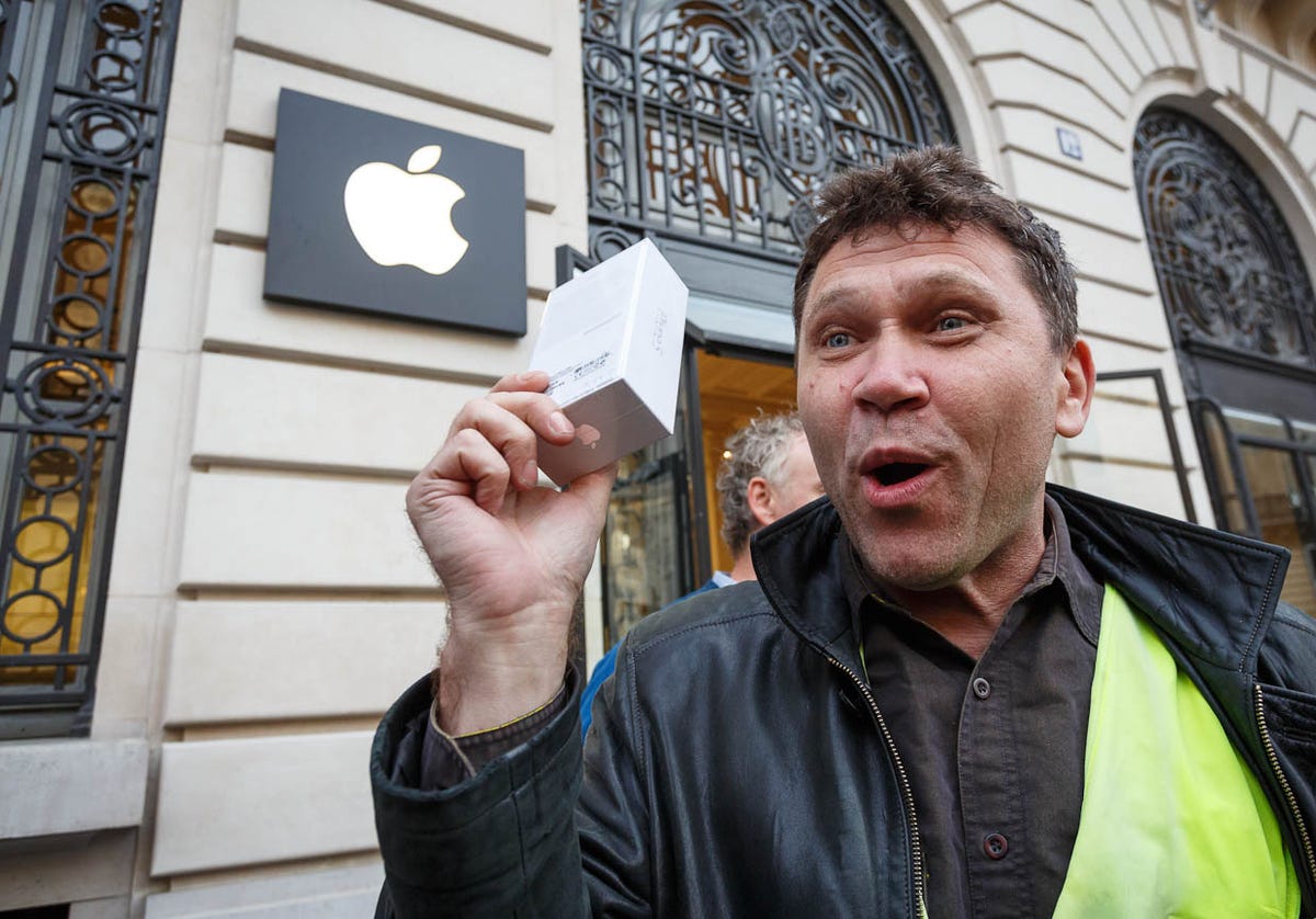 Mikhail Vorobyev, one of the early customers to buy an iPhone 5 at Apple's store in Paris, shows off his new purchase.