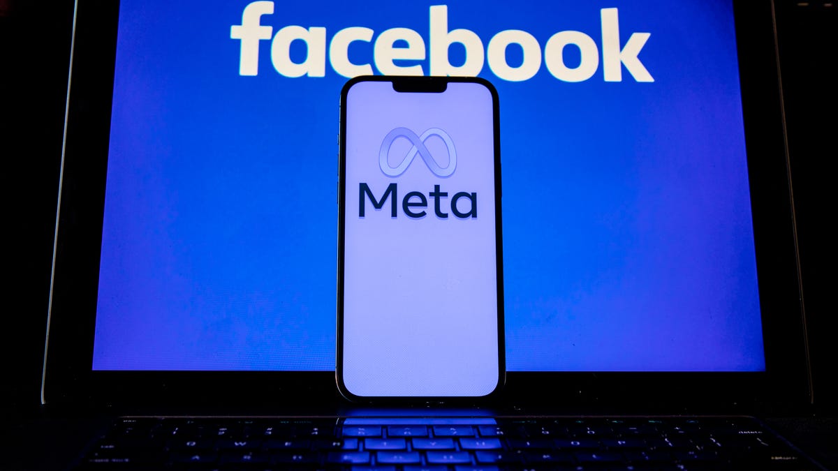 Meta's logo on a phone in front of Facebook's logo