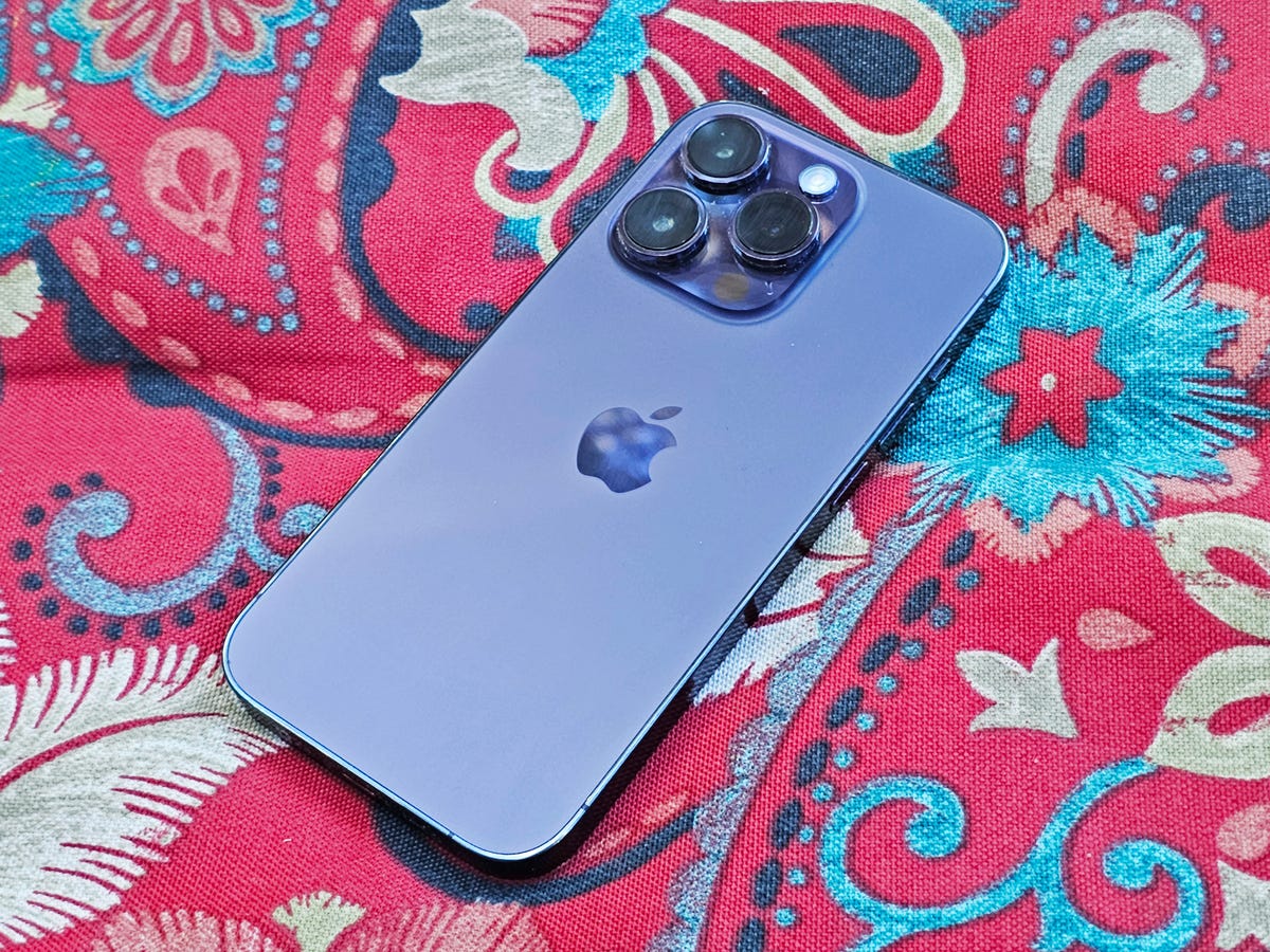 Purple iPhone 14 Pro on a red pillow