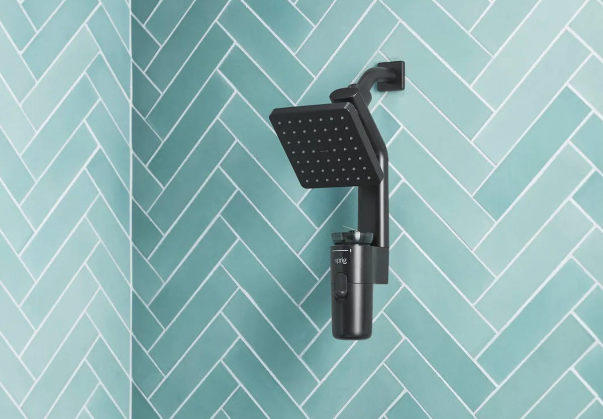 Kohler Sprig shower head in an aqua-colored tiled shower