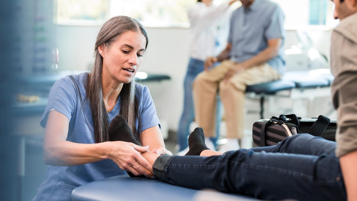 physical therapist examining ankle